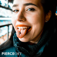 stylish woman sticking her tongue out with tongue piercing and barbell jewellery