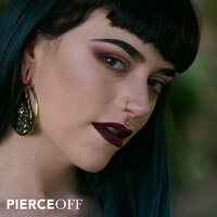 Cool alternative girl with bright gold nose ring piercing jewellery