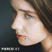 classically beautiful woman with black lip piercing stud
