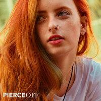 redhead girl leaning on rail with black nose ring in her nose piercing