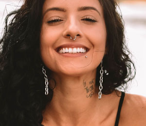 beautiful smiling woman with septum and lip piercing jewellery