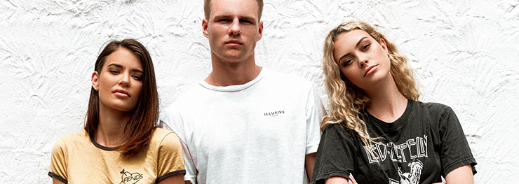 Three stylish friends standing in front of wall