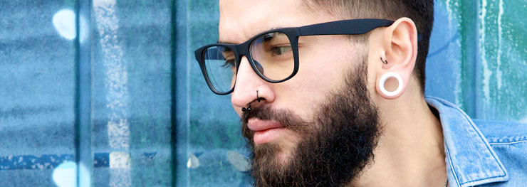 Man with beard and tragus, nose piercings